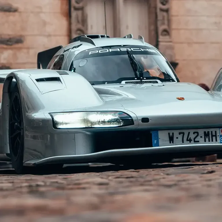 Unveiling the Porsche 963 RSP Silver Porsche 963 RSP with aerodynamic design parked on cobblestone street.